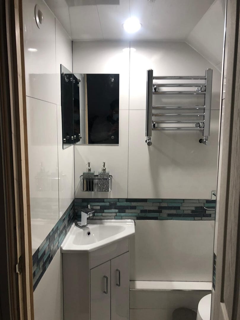 Corner sink and small heated towel rail in cloakroom