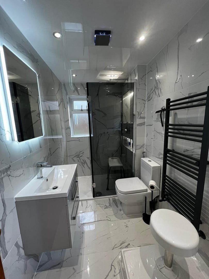 Bathroom 1: view 1 -sink with illuminated mirror over, shower cubicle, WC, heated towel rail.