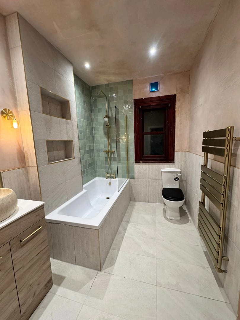 Refurbished bathroom 3 image 1 showing bath with shower over, heated towel rail