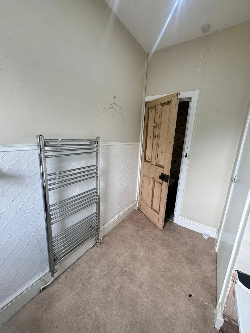 Bathroom 3 before showing doorway and chrome towel rail